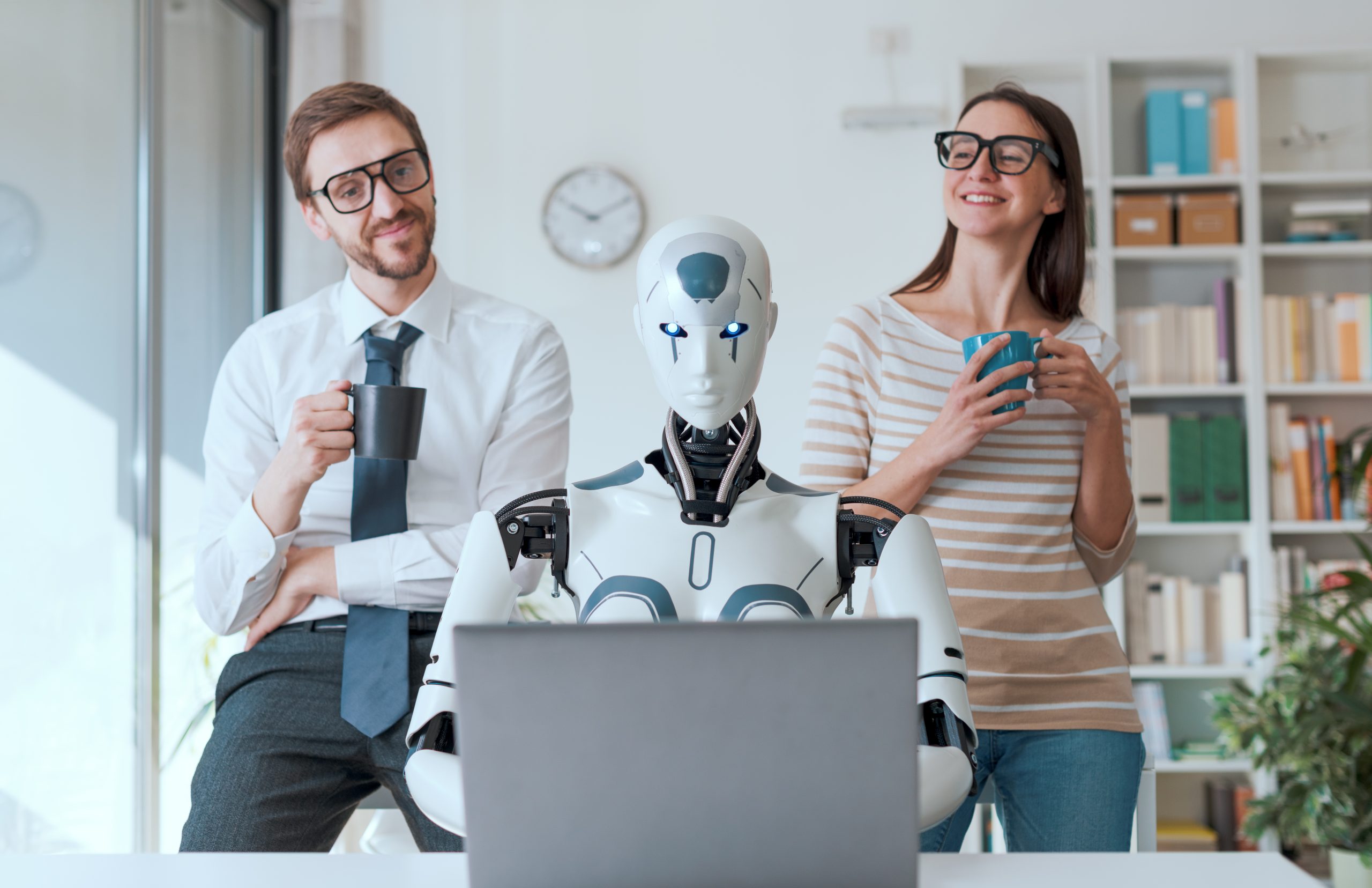 Happy business people supervising an AI robot working in the office